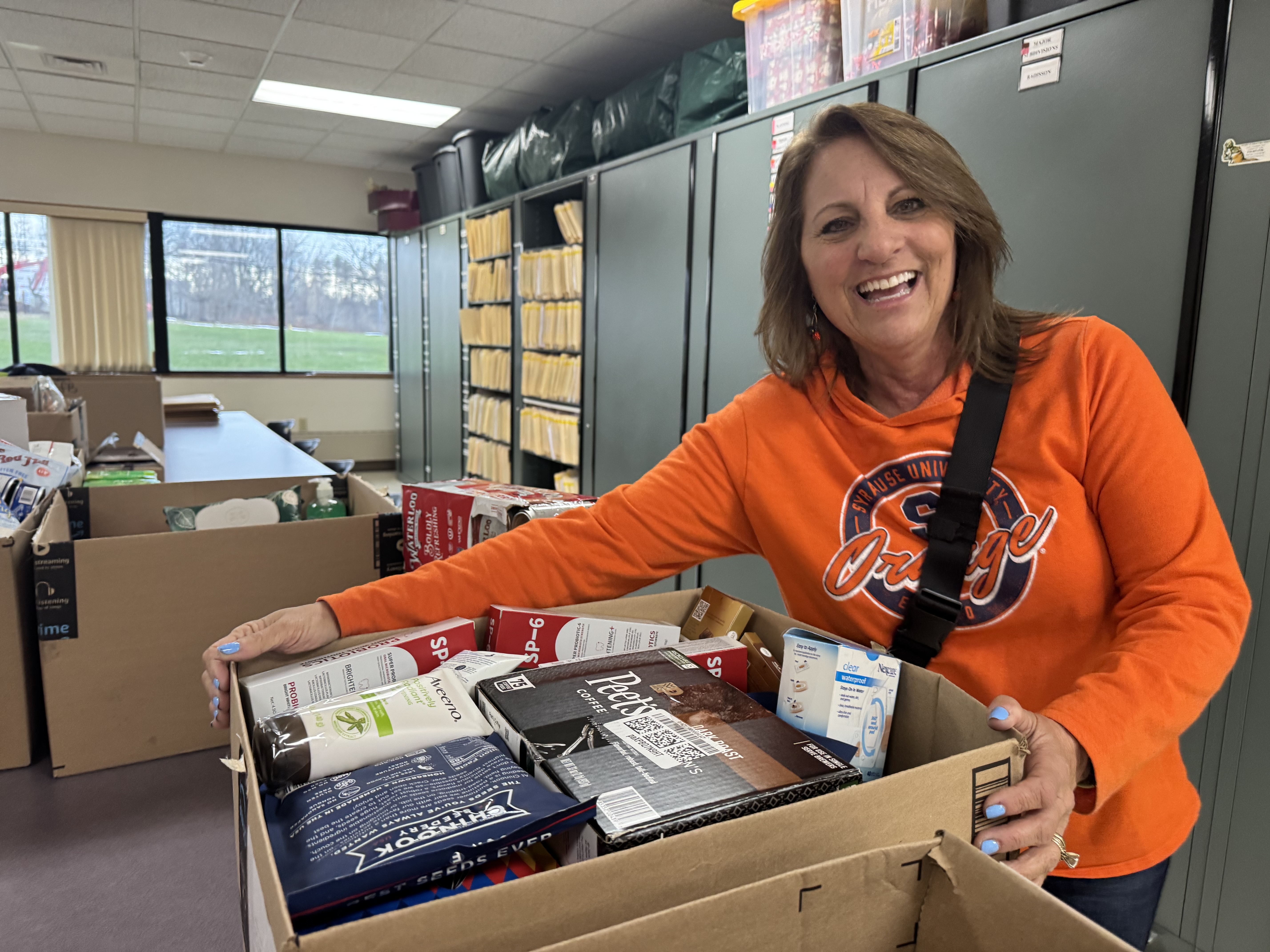 woman in white t-shirt and blue denim jeans sitting on brown cardboard box